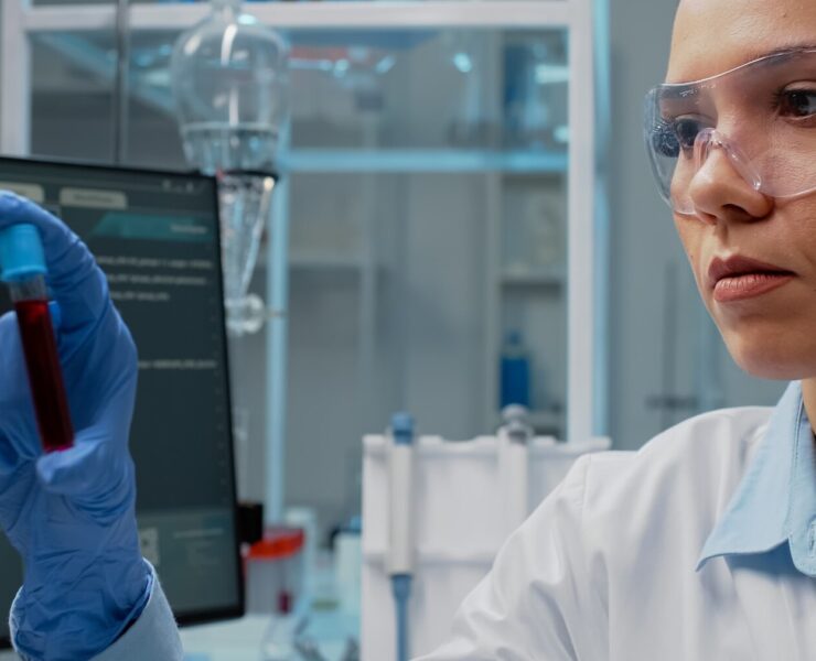 close-up-scientist-analyzing-lab-vacutainer-with-fluid_482257-9098